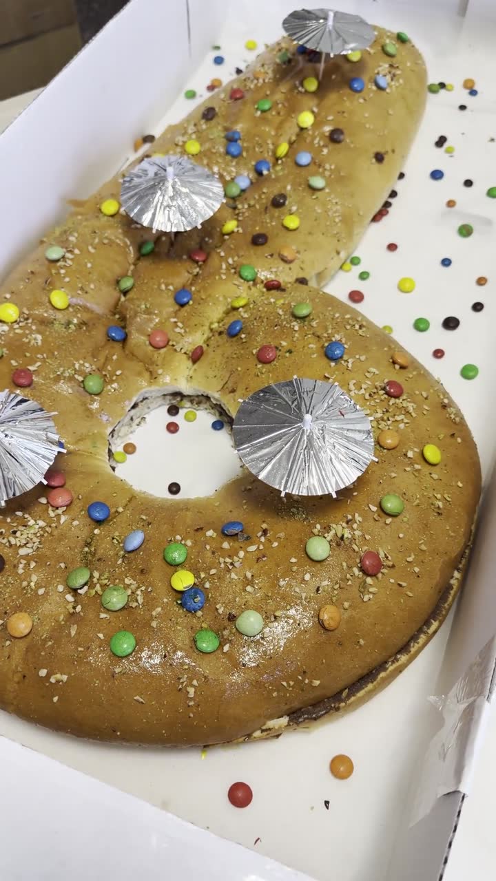 Torta di compleanno a forma di sei, decorata con confetti colorati