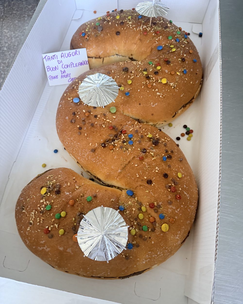 Torta di compleanno a forma di numero, decorata con confetti colorati